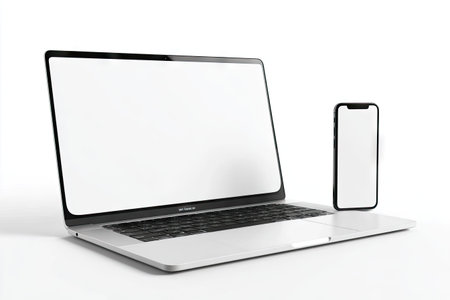 A modern laptop and smartphone are presented against a clean white backdrop. The screens of both devices are empty, ideal for inserting custom graphics or text. The composition features strong lighting, emphasizing the sleek design of the electronics. The image is suitable for various commercial and editorial applications.の素材
