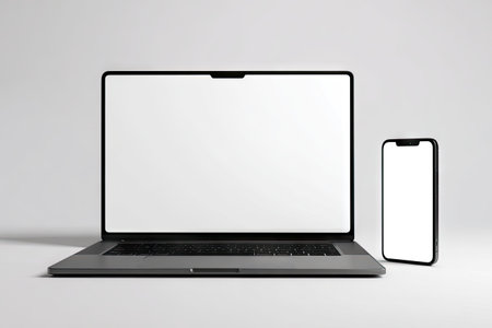 A laptop and smartphone are presented against a plain backdrop. The devices, with their screens illuminated, showcase a clean, minimalist aesthetic. The composition, featuring a front view and neutral tones, would suit various commercial projects requiring technology, communication, or digital display elements. The presentation emphasizes the devices themselves.の素材