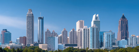 The image displays a cityscape featuring various skyscrapers under a bright blue sky. The composition highlights the architectural diversity and dense structures of the city, showcasing modern building designs. It can be used for commercial purposes related to urban planning, real estate, or general business concepts.の素材