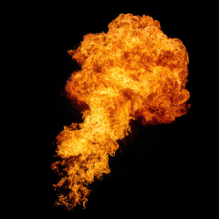 This image showcases a dynamic explosion of intense orange flames against a stark black backdrop. The flames exhibit a textured appearance with swirling patterns and a powerful, energetic form. Suitable for commercial applications, the image conveys concepts of destruction, energy, and dramatic visual impact within a studio environment.の素材