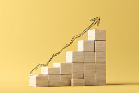 A wooden staircase is depicted, overlaid by a sketched arrow pointing upward. The composition utilizes a bright, uniform yellow background. The blocks have a neutral tone, creating contrast with the arrow. This image is ideal for representing concepts like success, growth, and achievement in various business and financial contexts.の素材