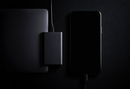 Power bank and smartphone on a black background. Top view, flat layの素材