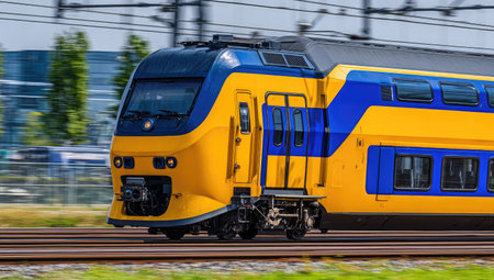 Modern high-speed passenger train moves along the rails on a sunny summer dayの素材