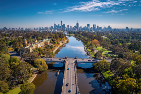 An aerial photograph showcases a cityscape with a river, bridges, and surrounding greenery. The image features a clear sky and buildings in the distance, with a bridge spanning the water. This scene suggests a metropolitan area, with potential uses in travel, architecture, or urban planning projects.の素材