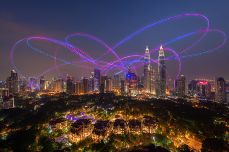 A nighttime cityscape features illuminated skyscrapers and residential areas, with colorful light trails overhead. The composition shows a dynamic urban environment under a dark sky. This image may be suitable for a variety of commercial and editorial purposes.の素材