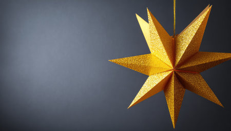 A single, golden star is suspended against a dark, gradient background. The star has multiple sharp points, exhibiting a textured surface. The lighting appears soft and even, highlighting the three-dimensional form. This image is suitable for holiday-themed projects or general decorative purposes, offering ample copy space.の素材