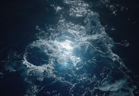Captured from an overhead perspective, this image showcases ocean waves illuminated by sunlight. The dynamic texture reveals frothy water in shades of blue and white, with contrasting areas of light and shadow. Suitable for backgrounds and illustrative applications, it can be used in projects to depict natural elements.の素材