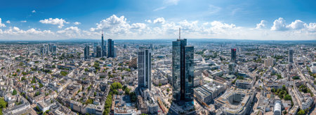 An expansive cityscape showcases numerous tall buildings and urban infrastructure under a clear, bright blue sky. The image displays a high-angle perspective with an emphasis on architectural design and urban planning. The natural lighting and composition suggest potential use in commercial projects or editorial publications related to development or city life.の素材