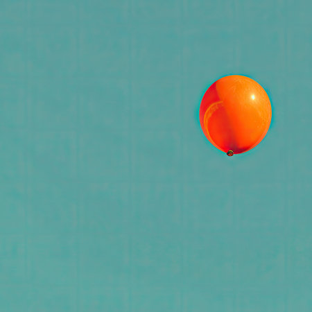 An orange balloon is displayed against a solid turquoise background. The image presents a clean composition, with the balloon in the upper right. The color palette consists of orange and turquoise tones. The image could be used for various projects, including promotional materials or design elements.の素材