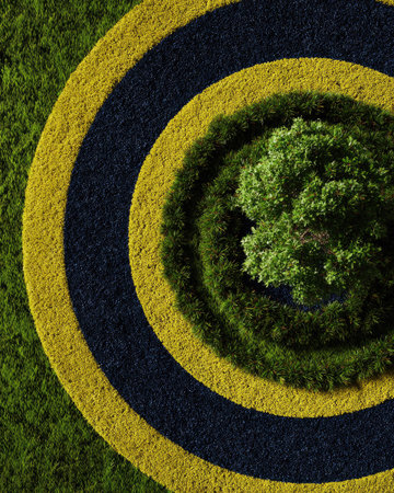 An overhead shot reveals a geometric pattern of layered circles in varying shades of green, yellow, and black. A central tree is surrounded by a textured, grassy surface. The image may be suitable for use in design, environmental, or abstract concepts. It avoids specific references or brand association.の素材