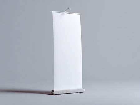 A vertical, isolated mockup showcases a blank roll up banner. The design features a white banner against a gray backdrop, suggesting a studio setting. The lighting is soft, highlighting the texture and form, while also providing copy space for advertisements, presentations, and marketing materials.の素材