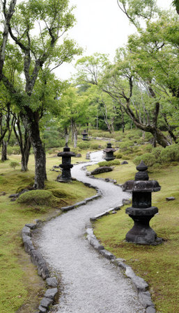 A tranquil scene features a meandering pathway, framed by lush greenery. The composition showcases stone lanterns, adding a touch of classic design, set amidst a vibrant landscape. This image exhibits a natural daylight, offering potential applications in travel, design, or wellness-themed content. The setting implies a sense of calm and tranquility.の素材