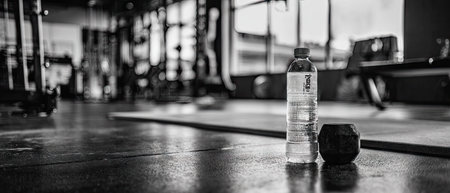 A bottle of water on the floor in the gym. Black and white photo.の素材