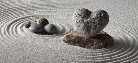 zen garden with stone in shape of heart and stones on sand backgroundの素材