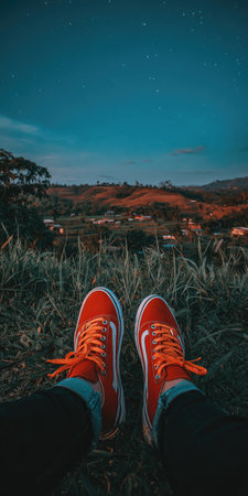 Red sneakers on the background of the starry sky and mountains.の素材