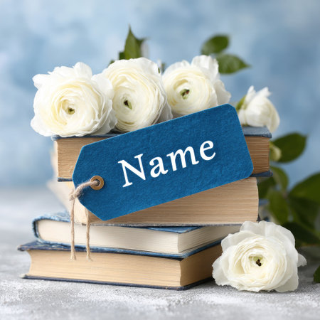 White roses and books with tag on light blue background, closeupの素材