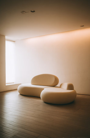 An inviting interior space showcases a contemporary curved sofa. The room features neutral tones and a warm, diffused lighting. The clean lines of the architecture and the stylish furniture suggest a modern aesthetic. Suitable for commercial projects or editorial use focusing on design or living.の素材
