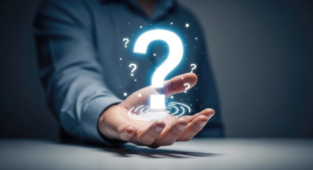 Close up of businessman hand holding question mark sign in palm with dark backgroundの素材