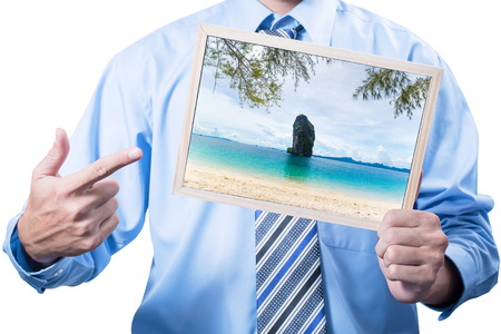 Hands of businessman holding frame with beach picture in frame.の写真素材