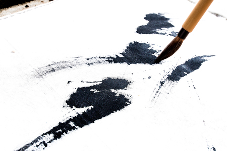 Chinese brushes draw on white papersの写真素材