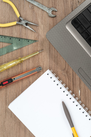 Blank notepad and laptop on office wooden table, top viewの写真素材