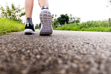 fitness woman legs running at forest trailの写真素材