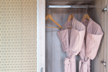 bathrobe with wooden hangers in clothesetの写真素材