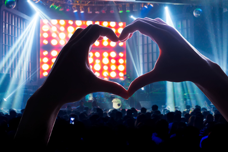 engage your audience with the power of music, with a heart shaped hands shadowの写真素材