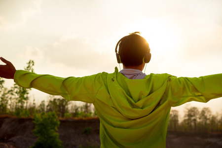 man listening music headphones from smartphone at natural outdoorの写真素材