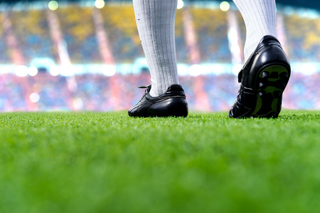 Foot of soccer player or football player walk on green grass ready to play soccer match for the winner with soccer stadium backgrounds.の写真素材