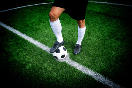Soccer player ready to play at start kick off point in soccer field.