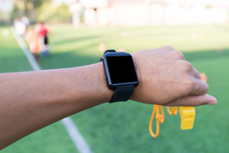 Close-up hands of Coach using his smart watch is coaching Children Training In Soccer Team