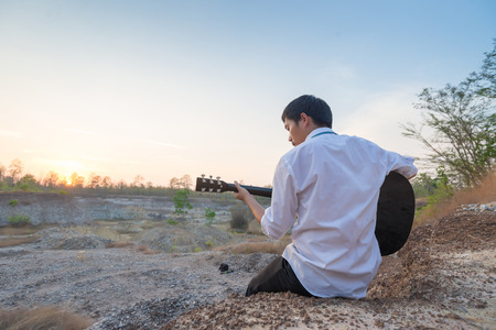 Businessman playing guitar at natural outdoorの写真素材
