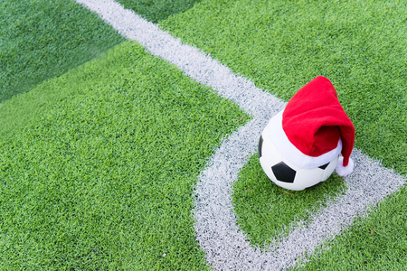 Santa Claus red hat on soccer ball at green grassの写真素材