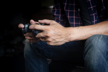 Hands Holding a Joystick Controller while playing a video games at homeの写真素材