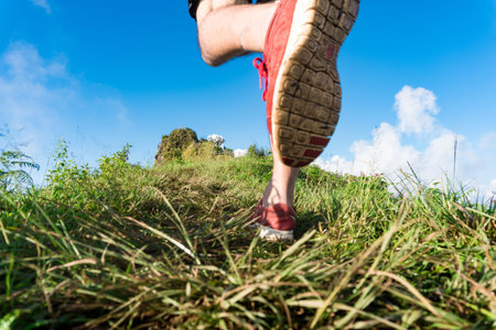 close-up Foot athlete Trail running workout on rocky terrain outdoors for fitness and healthy...