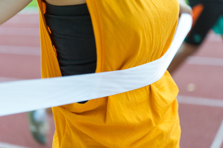 Young Female athletes fitness run cross finish line running track field achieving accomplishment healthcareの写真素材