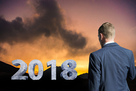Businessman Standing on mountains at Sunset with concrete text 2018 idea market plan in new yearの写真素材