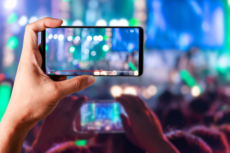 People hands use smart phones record video concert music festival live streaming video on internet to social media comment chat to Friendの写真素材