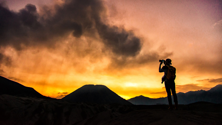 Photographer taking photos on beautiful moment mountains at Sunsetの写真素材