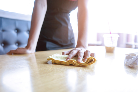 Waitress cleaning the table in coffee shopの写真素材