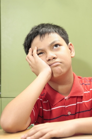 A Photo of a boy thinkingの写真素材