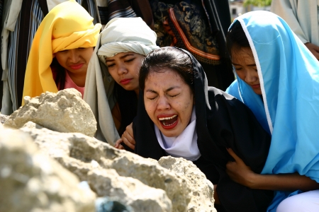 Cainta, Rizal, Philippines. March 29, 2013. Actress in the role of Mary grieves as she watch Jesus on a cross in a re-enactment of Christ's crucifixion and death. A tradition in the Philippines called "Senakulo" is held yearly every Holy Week.のeditorial素材