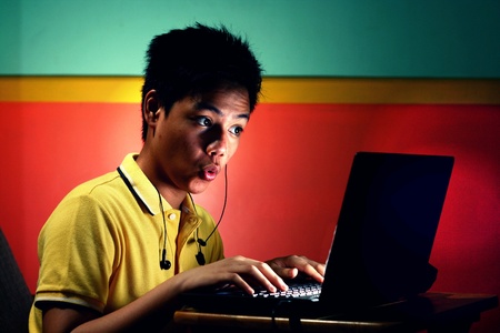 Young asian teen with a laptop computerの素材