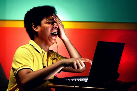 Young asian teen with a laptop computerの素材