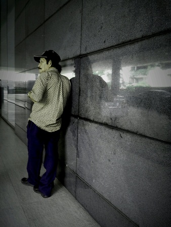 Man leaning on a marble tile wallの素材
