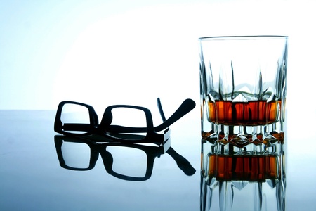 Alcoholic drink in a glass and a pair of eyeglassesの素材