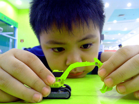 Young boy playing with a toy backhoe