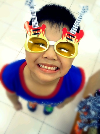 Young asian kid wearing funny sunglassesの素材