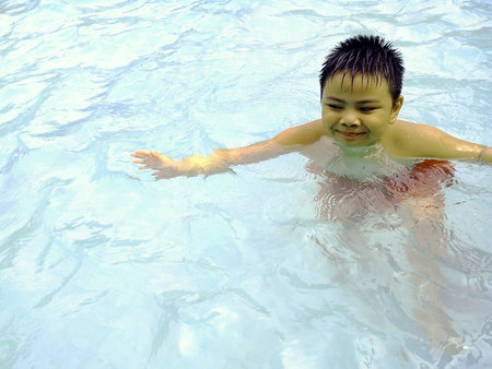 Young boy swimming in a swimming pool